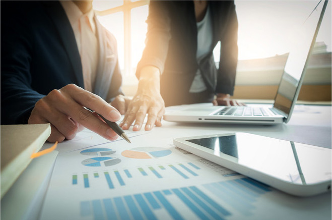 Two people planning a commercial move over charts and an open laptop